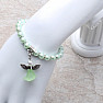 Children&#39;s bracelet made of light green glass beads with an angel